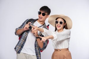 Men and women dressed to travel, wear glasses, and take pictures