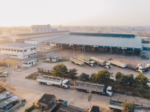 aerial-view-factory-trucks-parked-near-warehouse-daytime