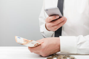 man-holding-money-using-calculator