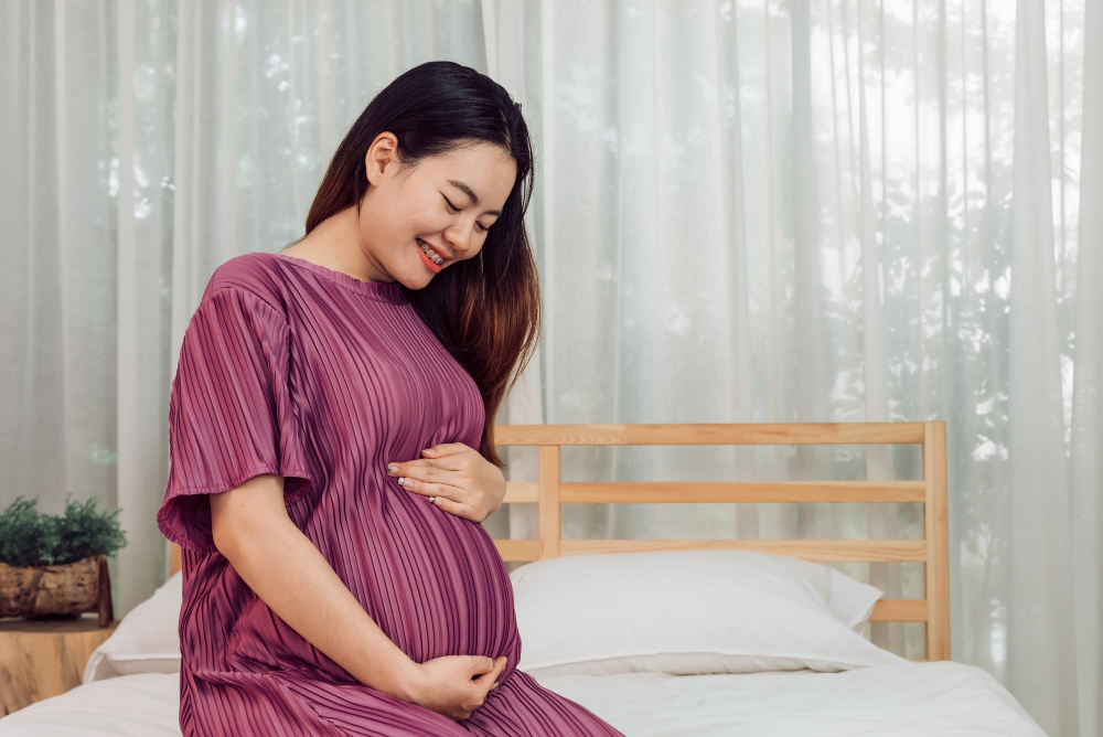 portrait-young-adult-asian-pregnant-woman-touching-her-belly-with-love-home